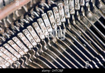 Abstrakter Hintergrund mit Metallteil und Elementen einer alten Schreibmaschine, ausgewählter Fokus Stockfoto