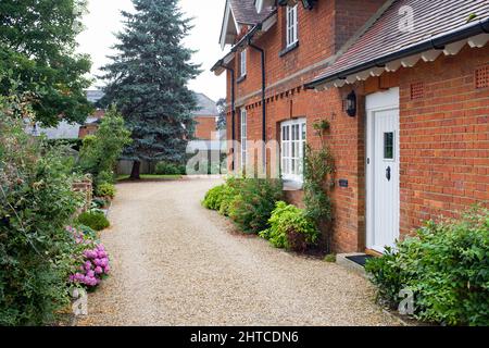 Garten und Schotterzufahrt außerhalb des britischen Landhauses im Sommer. Viktorianisches englisches Haus oder Herrenhaus Stockfoto