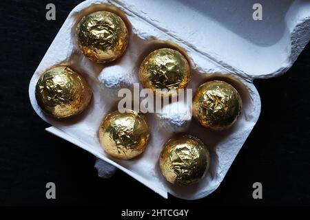 Nahaufnahme von Schokoladen-Ostereiern in Goldfolie auf isoliertem Hintergrund eingewickelt Stockfoto