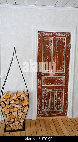 Alte Tür und Stapel Feuerholz im Wohnzimmer Stockfoto