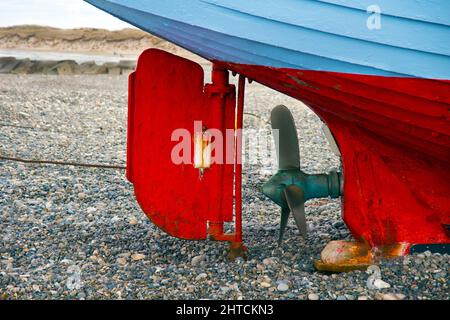 Nahaufnahme des Schiffspropellers und des Ruders, die auf einem felsigen Strand stehen Stockfoto