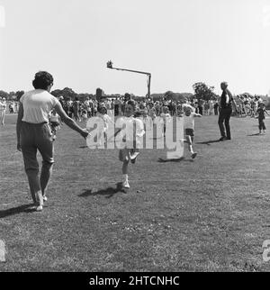 Laing Sports Ground, Rowley Lane, Elstree, Barnett, London, 21/06/1986. Ein Mädchen, das beim Familientag 1986 auf dem Laing's Sports Ground die Ziellinie eines der Kinderrennen überquert. Über 2500 Menschen nahmen am Familientag Teil und erzogen über &#XA3;700 für die diesjährige wohltätige Organisation der British Heart Foundation. Zu den Attraktionen gehören Gastauftritte der Darsteller der Fernsehsendung Grange Hill, eine Hüpfburg, Eselreiten, Punch- und Judy-Shows, Pierre the Clown, Kinderrennen, mit verbundenen Augen Stunt Driving und Golf sowie Fußballturniere mit sechs Spielern. Stockfoto