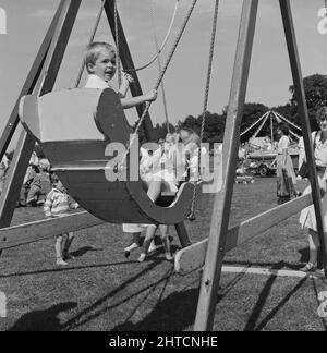 Laing Sports Ground, Rowley Lane, Elstree, Barnett, London, 21/06/1986. Kinder reiten auf einer Bootsschaukel beim Familientag 1986 auf dem Laing's Sports Ground. Über 2500 Menschen nahmen am Familientag Teil und erzogen über &#XA3;700 für die diesjährige wohltätige Organisation der British Heart Foundation. Zu den Attraktionen gehören Gastauftritte der Darsteller der Fernsehsendung Grange Hill, eine Hüpfburg, Eselreiten, Punch- und Judy-Shows, Pierre the Clown, Kinderrennen, mit verbundenen Augen Stunt Driving und Golf sowie Fußballturniere mit sechs Spielern. Stockfoto