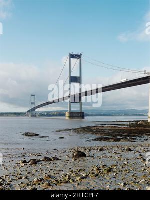 Severn Bridge, M48, Aust, South Gloucestershire, 10/11/1987. Die Severn-Brücke vom Aust-Strand bei Ebbe, gesehen während der von Laing geleisteten Verstärkungsarbeiten. Das ursprüngliche Design und der Bau der Severn-Brücke hatten das erhöhte Verkehrsaufkommen seit ihrer Fertigstellung im Jahr 1966 unterschätzt, und obwohl es auf eine Lebensdauer von 120 Jahren gebaut wurde, wurde festgestellt, dass bereits nach 20 Sanierungsarbeiten erforderlich waren. Laing Industrial Engineering &amp; Construction gewann den &#XA3;29,5m-Vertrag vom Ministerium für Verkehr und Stärkung der Arbeit an allen Elementen der Struktur begann im Mai 1987. Das Projekt wurde in abgeschlossen Stockfoto