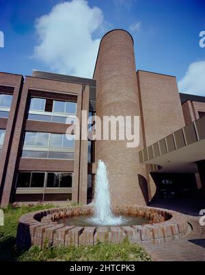 Sir John Laing Building, Page Street, Mill Hill, Barnett, London, 18/05/1981. Der runde Brunnen und der U-förmige Treppenturm am Vordereingang zum Sir John Laing Building, Mill Hill. Das Sir John Laing-Gebäude, benannt nach dem Präsidenten des Unternehmens, der im Januar 1978 im Alter von 98 Jahren starb, wurde zwischen 1977 und 1980 erbaut und wurde seit 1974 geplant. Das Gebäude schloss eine Entwicklungsphase im Laing's Mill Hill Headquarter Complex ab, ein Gebiet, das das Unternehmen seit seinem Umzug von Carlisle im Jahr 1922 besetzen hatte. Bis 1988 jedoch eine große Umstrukturierung des Unternehmens und bedeutete ein Ganzes Stockfoto