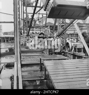 Skegness, East Lindsey, Lincolnshire, 22/05/1954. Ein Mann und ein Kind auf einem Riesenrad während einer Laing-Mitarbeiterreise nach Skegness. Im Jahr 1947, nach einer siebenjährigen Pause, hatte Laing seine „Ausflüge in die Umgebung“ für Mitarbeiter und ihre Familien wiederbelebt, wobei die Reisen im Mai und Juni stattfinden. Im Jahr 1954 waren sieben Ausflüge geplant, die über fünf Wochen im Mai und Juni stattfinden sollen. Diese Reise nach Skegness war für Mitarbeiter und ihre Familien aus den Midlands und South Yorkshire. Stockfoto