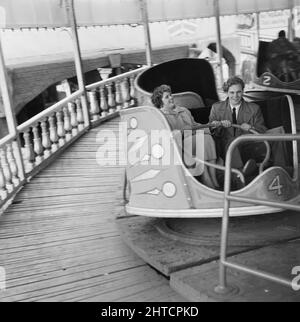 Skegness, East Lindsey, Lincolnshire, 22/05/1954. Ein Mann und eine Frau reiten auf einem Walzer während einer Laing-Mitarbeiter-Reise nach Skegness. Im Jahr 1947, nach einer siebenjährigen Pause, hatte Laing seine „Ausflüge in die Umgebung“ für Mitarbeiter und ihre Familien wiederbelebt, wobei die Reisen im Mai und Juni stattfinden. Im Jahr 1954 waren sieben Ausflüge geplant, die über fünf Wochen im Mai und Juni stattfinden sollen. Diese Reise nach Skegness war für Mitarbeiter und ihre Familien aus den Midlands und South Yorkshire. Stockfoto