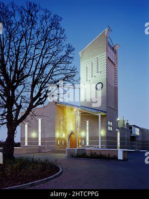 St Mary's Church, New Road, Peterborough, 20/11/1991. St Mary's Church, von Südwesten aus gesehen, in der Dämmerung, mit Lichtern, die den Turm und die verglaste Veranda erleuchten. Der Bau der St. Mary &#X2019;s Kirche begann im Jahr 1989 und wurde im Jahr 1991 abgeschlossen. Die Kirche wurde an der Stelle der ehemaligen Kirche der Heiligen Jungfrau Maria errichtet, einer Pfarrkirche aus der Mitte des 19.. Jahrhunderts, die in Verfall geraten war. Das Grundstück, auf dem die ursprüngliche Kirche stand, wurde verkauft und ein neues Gebäude, bekannt als Churchgate, errichtet: Gemeinschaftseinrichtungen, Büros und eine moderne Kirche. Originalelemente, darunter die Uhr, Buntglas und Stockfoto