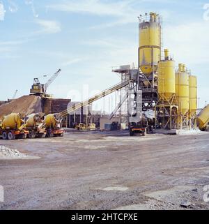 Steel Works, Redcar and Cleveland, North Yorkshire, 16/09/1975. Eine Betonzuschlaganlage mit mehreren Zementlagersilos während der Bauarbeiten im British Steel Works in Redcar. Laing war nur einer von vielen Auftragnehmern, die die Werke bei Redcar errichteten, und war hauptsächlich für den Bau der Rohstoffannahme und -Lagerung verantwortlich, einschließlich eines Netzes von Tunneln, in denen Förderbänder aus Beton untergebracht waren. Laing war für die Fundamente für das Schwerwerk auf dem gesamten Gelände verantwortlich, allein der Hochofen selbst benötigte Fundamente von 6.000 Kubikmetern Betonkonsis Stockfoto