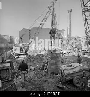 Vintners Place, Upper Thames Street, Queenhithe, London, 01/10/1990. Ein Arbeiter, der mit einem Kran in das Stahlgehäuse eines der gebohrten Pfahlfundamente am Winzerplatz herabgelassen wurde, um eine Inspektion durchzuführen. Laing unternahm den &#XA3;79m Managementvertrag für den Bau einer 37.000sqm hochwertigen Büroentwicklung bei Winzern Place zwischen März 1989 und Dezember 1992. Die Arbeiten vor Ort begannen im Juni 1989 mit dem Abriss von 10 Gebäuden, darunter das Vintry House und Kennet Wharf am Flussufer. Die gelistete fa &#XE7;ade des Thames House am Queen Street Place wurde erhalten und inkorportiert Stockfoto