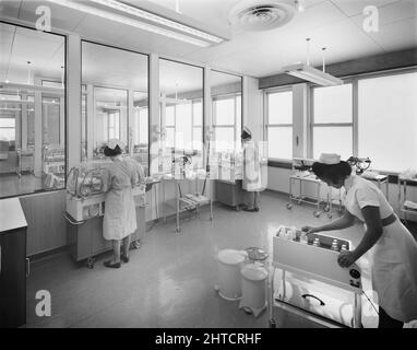 Walsgrave Hospital, Clifford Bridge Road, Walsgrave on Sowe, Coventry, West Midlands, 17/03/1967. Zwei Krankenschwestern neigen dazu, Babys in Inkubatoren zu bekommen, während eine dritte einen Wagen mit Milchflaschen in der After Care Unit im Walsgrave Hospital inspiziert. Stockfoto