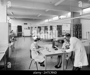 West Cumberland Hospital, Homewood Road, Homewood, Whitehaven, Copeland, Cumbria, 27/08/1964. Zwei studentische Krankenschwestern, die in der Krankenschwestern-Schule im West Cumberland Hospital in die Blutdruckmessung eingewiesen wurden. Stockfoto