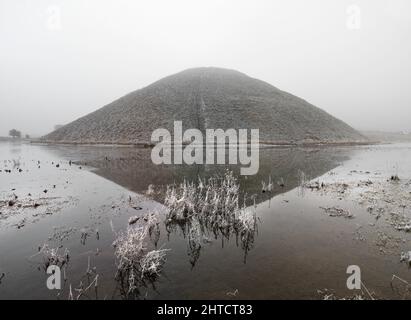 Silbury Hill, Avebury, Wiltshire, 2012. Allgemeiner Blick nach Süden über wasserbemalte Felder in Richtung Silbury Hill, an einem nebligen Wintermorgen. Stockfoto