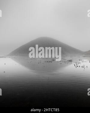 Silbury Hill, Avebury, Wiltshire, 2012. Allgemeiner Blick auf Silbury Hill, der sich an einem nebligen Wintermorgen über und in wasserbesäten Feldern spiegelte. Stockfoto