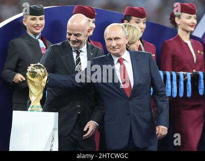 Datei-Foto vom 15-07-2018 von FIFA-Präsident Gianni Infantino (links) und dem russischen Präsidenten Wladimir Putin mit der WM-Trophäe. Während die russische Invasion in der Ukraine andauert, sagte die FIFA am Sonntag, dass Russland internationale Spiele in neutralen Ländern ohne Anhänger, Fahnen und Hymnen spielen muss. Angesichts der WM-Play-offs am Horizont stieß die Entscheidung auf Kritik, und der polnische Verband, der Russland am 24. März treffen sollte, sagte, dass er das Spiel nicht erfüllen werde und bezeichnete den Schritt als „inakzeptabel“. Ausgabedatum: Montag, 28. Februar 2022. Stockfoto