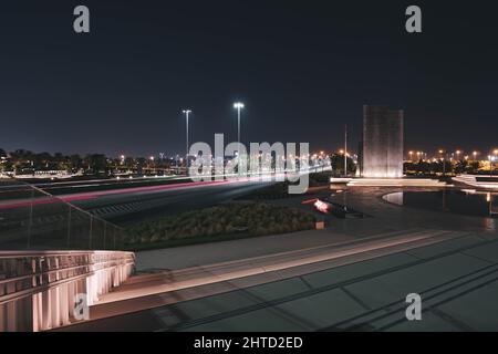 Faszinierender Blick auf die beleuchtete Straße mit fahrenden Autos am Abend in Abu Dhabi, VAE Stockfoto