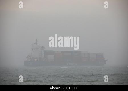 Bullens Bay, Cork, Irland. 28.. Februar 2022. Das Containerschiff BG Emerald ist im Nebel kaum zu sehen, da es vor dem Old Head of Kinsale, Co. Cork, Irland, in Bullens Bay vor Anker liegt. - Credit; David Creedon / Alamy Live News Stockfoto