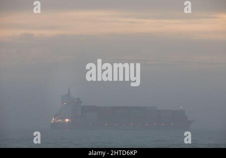 Bullens Bay, Cork, Irland. 28.. Februar 2022. Das Containerschiff BG Emerald ist im Nebel kaum zu sehen, da es vor dem Old Head of Kinsale, Co. Cork, Irland, in Bullens Bay vor Anker liegt. - Credit; David Creedon / Alamy Live News Stockfoto