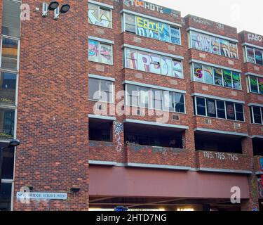 Graffiti schmückt die Wände und Fenster eines stillgebliebenem Gebäudes in der New Bridge Street West im cuty Centre von Newcastle. Stockfoto