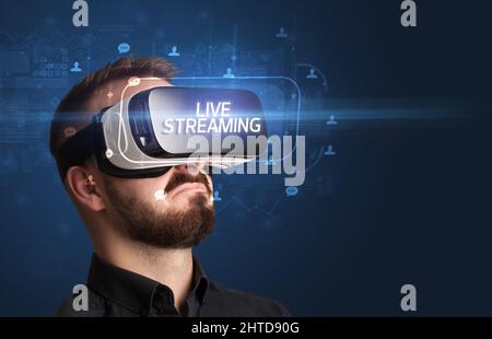 Geschäftsmann schaut durch Virtual Reality Brille, Social-Media-Konzept Stockfoto