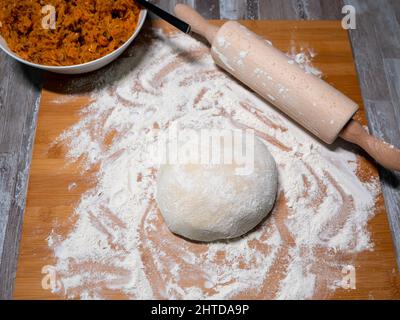 Teig für Knödel, Kohlfüllung an der Seite und ein Nudelholz Stockfoto