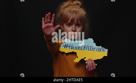 KIEW, UKRAINE - 24. Februar 2022: Verstörtes obdachloses Mädchen, das gegen die Kriegsinschrift protestiert, übergibt die Ukraine Stockfoto