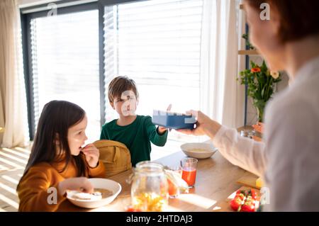 Kleine Kinder packen Lunchboxen zur Schule am Morgen in der Küche. Stockfoto