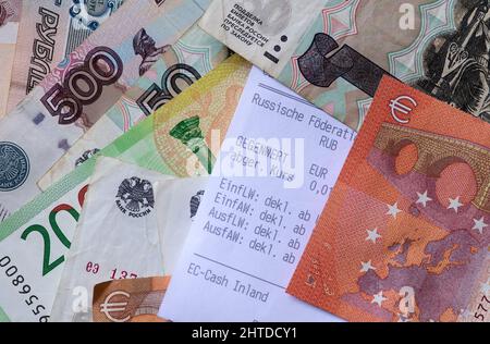 28. Februar 2022, Bayern, München: Russische Rubel-Banknoten, Euro-Scheine und ein Wechselbeleg liegen auf einem Tisch. Die Europäische Union hat ihre strengen Sanktionen gegen die russische Zentralbank am Montagabend in Kraft gesetzt. Laut EU-Kommissionspräsident von der Leyen enthalten sie ein Verbot von Transaktionen mit dem Finanzinstitut. Foto: Sven Hoppe/dpa Stockfoto