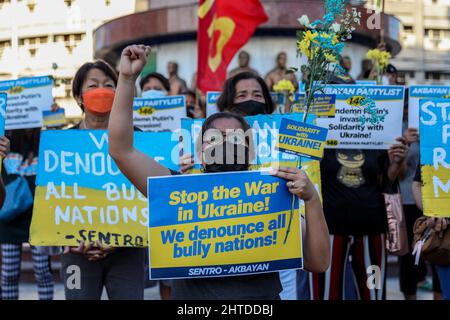 Manila, Philippinen. 28.. Februar 2022. Philippinische Aktivisten halten Blumen und Schilder mit den Farben der ukrainischen Flagge in der Hand, als sie sich als Reaktion auf die russische Invasion in der Ukraine bei einem Protest am Boy Scouts Circle in Quezon City, Philippinen, versammelten. 28. Februar 2022. Kredit: ZUMA Press, Inc./Alamy Live Nachrichten Stockfoto