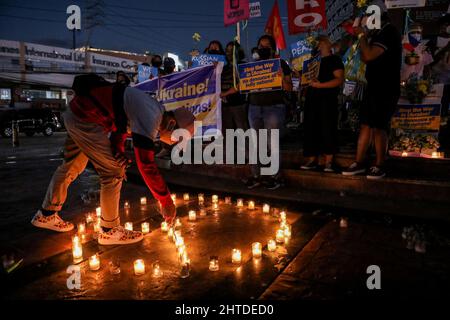 Manila, Philippinen. 28.. Februar 2022. Philippinische Aktivisten zünden Kerzen an und halten Schilder mit den Farben der ukrainischen Flagge auf, als sie sich als Reaktion auf die russische Invasion in der Ukraine bei einem Protest am Boy Scouts Circle in Quezon City, Philippinen, am Montag versammelten. 28. Februar 2022. Kredit: ZUMA Press, Inc./Alamy Live Nachrichten Stockfoto