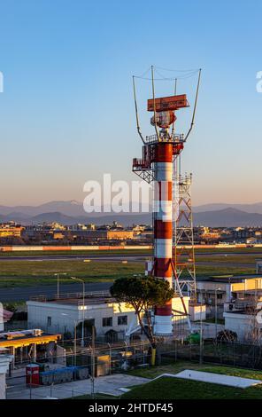 Vertikale Aufnahme eines rot-weiß gestreiften Funkturms und einer Start- und Landebahn des Flughafens Stockfoto
