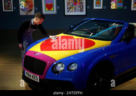 Ein Gallery Assistant posiert mit dem weltweit ersten und einzigen britischen Pop-Art Bentley, einem Bentley Continental GT V8 S Cabrio aus dem Jahr 2016, das von Sir Peter Blake entworfen wurde und auf £300.000 - 400.000 geschätzt wird, während eines Fotoalles für Bonhams' bevorstehenden British Cool Sale in Bonhams, New Bond Street, London. Bilddatum: Montag, 28. Februar 2022. Stockfoto