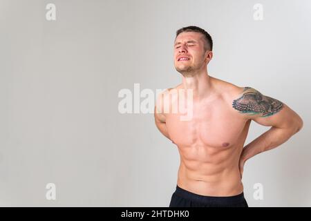 Ein Mann Rückenschmerzen hält seine Hand auf seinem Rücken Schmerzen Verletzungen Verletzungen, Rückenschmerzen Krankheit hält. Anspannung Nackenerkrankung leiden attraktiv Stockfoto