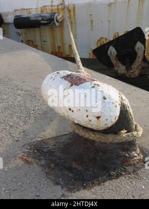 Alte rostige Poller und Seil auf einem traditionellen Hafenpier Stockfoto