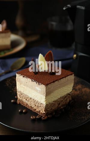 Tiramisu-Kuchen. Konzept für ein leckeres Dessert mit einer Scheibe Tiramisu-Kuchen, Nahaufnahme, vertikal. Tiramisu-Kuchen Stockfoto