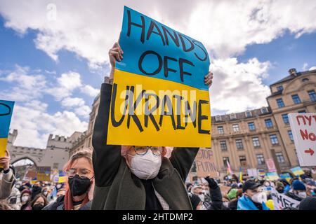 Die alte Frau hält bei der Friedensdemonstration in München ein Schild mit der Aufschrift „Hände weg von der Ukraine“ Stockfoto