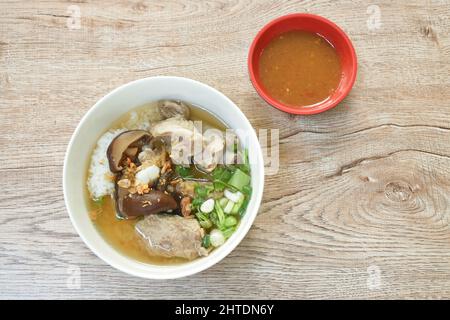 Gekochter Reis mit Schweineknochen und schwarzen Pilz in Suppe auf Schüssel schneiden Stockfoto