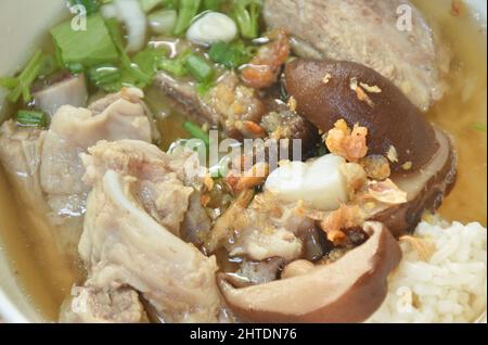 Gekochter Reis mit Schweineknochen und schwarzen Pilz in Suppe auf Schüssel schneiden Stockfoto