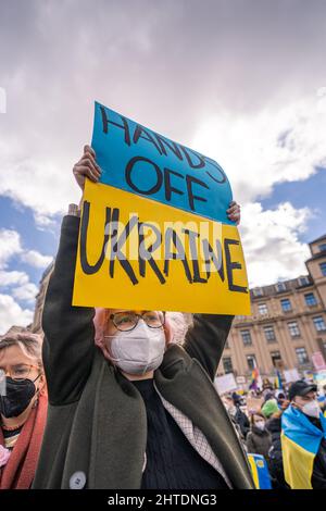 Die alte Frau hält bei der Friedensdemonstration in München ein Schild mit der Aufschrift „Hände weg von der Ukraine“ Stockfoto