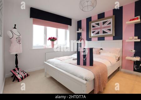 Modernes Schlafzimmer im neu erbauten Haus, Bettüberwurf, pinkfarbenes Beige-Design, Jack Wills-Thema Stockfoto