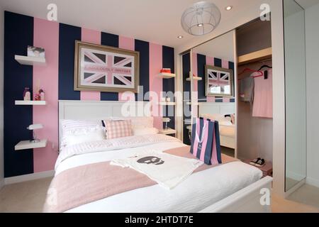 Modernes Schlafzimmer im neu erbauten Haus, Bettüberwurf, pinkfarbenes Beige-Design, Jack Wills-Thema Stockfoto