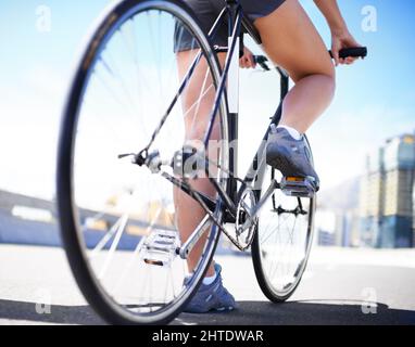 Radfahren ist eine hervorragende Möglichkeit, sich zu Formen. Beschnittene Ansicht einer Radfahrerin auf ihrem Fahrrad. Stockfoto
