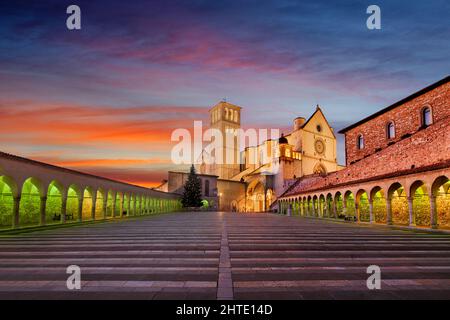 Assisi, Italien mit der Basilika des Heiligen Franziskus von Assisi in der Abenddämmerung. Stockfoto