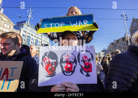 The Dam, Amsterdam, Niederlande. Sonntag, 27.. Februar 2022. Rund 15,000 Demonstranten versammelten sich heute Nachmittag am Amsterdamer Staudamm, um Solidarität mit der ukrainischen Bevölkerung zu zeigen und die russische Invasion von Präsident Putin zu verhindern. Schätzungsweise 100,000 Menschen protestierten in Europa und zahlreiche Russen schlossen sich den Demonstranten am Staudamm an, um Solidarität zu zeigen. Auch in den niederländischen Städten Groningen und Heerlen gingen Menschen auf die Straße. Bildunterschrift: Junges Mädchen hält eine Plakode in nationalistischen Farben hoch. Kredit: Charles M Vella/Alamy Live Nachrichten Stockfoto