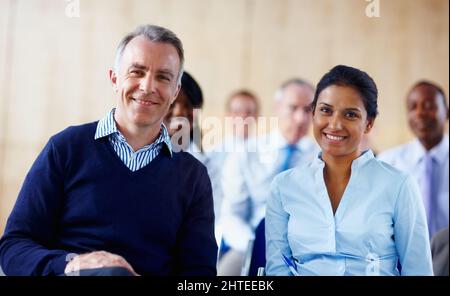 Leitende Angestellte neben dem Kollegen. Konzentrieren Sie sich auf Senior Business man mit weiblicher Führungskraft in Innenräumen. Stockfoto