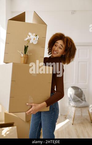 Porträt einer Frau, die einen schweren Karton in der Hand hält Stockfoto