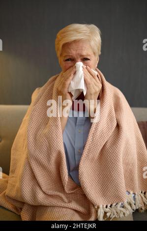Ungesunde kranke alte Frau in Decke gewickelt Stockfoto