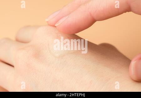 Transparentes Gel auf einer weiblichen Hand. Frau, die feuchtigkeitsspendendes Gel auf ihr Handgelenk aufträgt Stockfoto