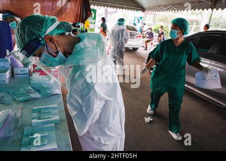 Bangkok, Thailand. 28.. Februar 2022. Ein Mitarbeiter des Gesundheitswesens sah Prüfergebnisse von einem ATK (Antigen Test Kit) an einer Drive-Thru-Teststelle. Drive-Thru und Walk-in ATK (Antigen Test Kit) Abstrichtests am Southern Bus Terminal in Bangkok, Thailand. Kredit: SOPA Images Limited/Alamy Live Nachrichten Stockfoto