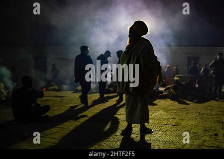 Kathmandu, Nepal. 28.. Februar 2022. Ein Sadhu, heilige Männer und Anhänger von Lord Shiva wird am Vorabend des Maha Shivaratri-Festivals im Pashupatinath-Tempel in Kathmandu, Nepal, am Montag, dem 28. Februar 2022, in einer Silhouette gezeigt. Tausende von Sadhus aus Indien und Nepal kommen, um das Maha Shivaratri-Fest zu feiern, indem sie Marihuana rauchen, ihre Körper mit Asche beschmieren und Gebete für den hinduistischen Gottheitsherrn Shiva anbieten. (Bild: © Skanda Gautam/ZUMA Press Wire) Stockfoto